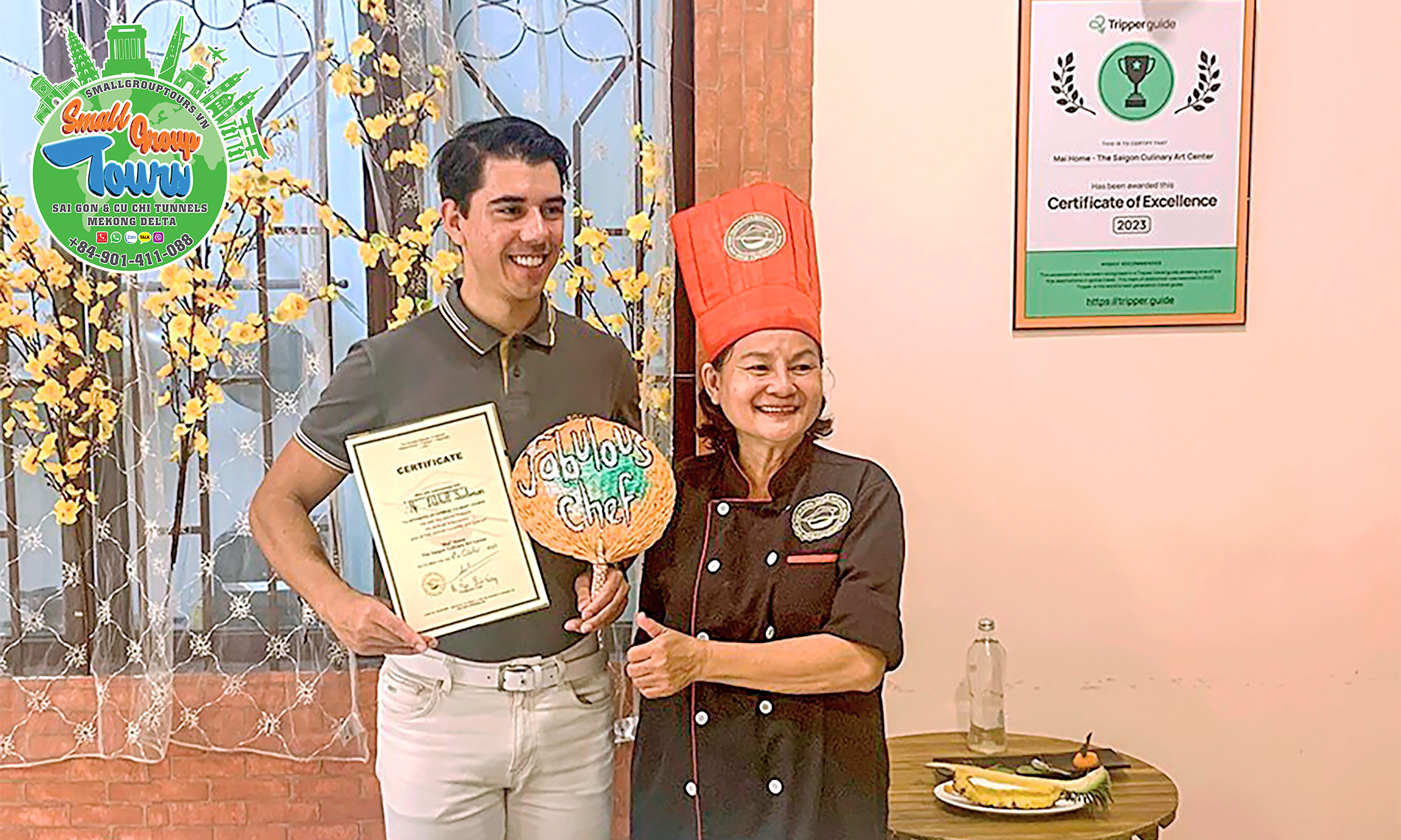 A proud moment unfolds as a tourist receives a certificate for participating in the cooking class, presented by the accomplished chef.